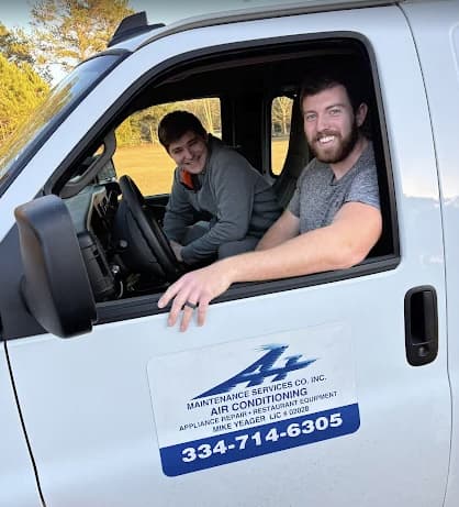 The A+ Maintenance team in their branded company truck, with the door showing the company name, license, and phone number.