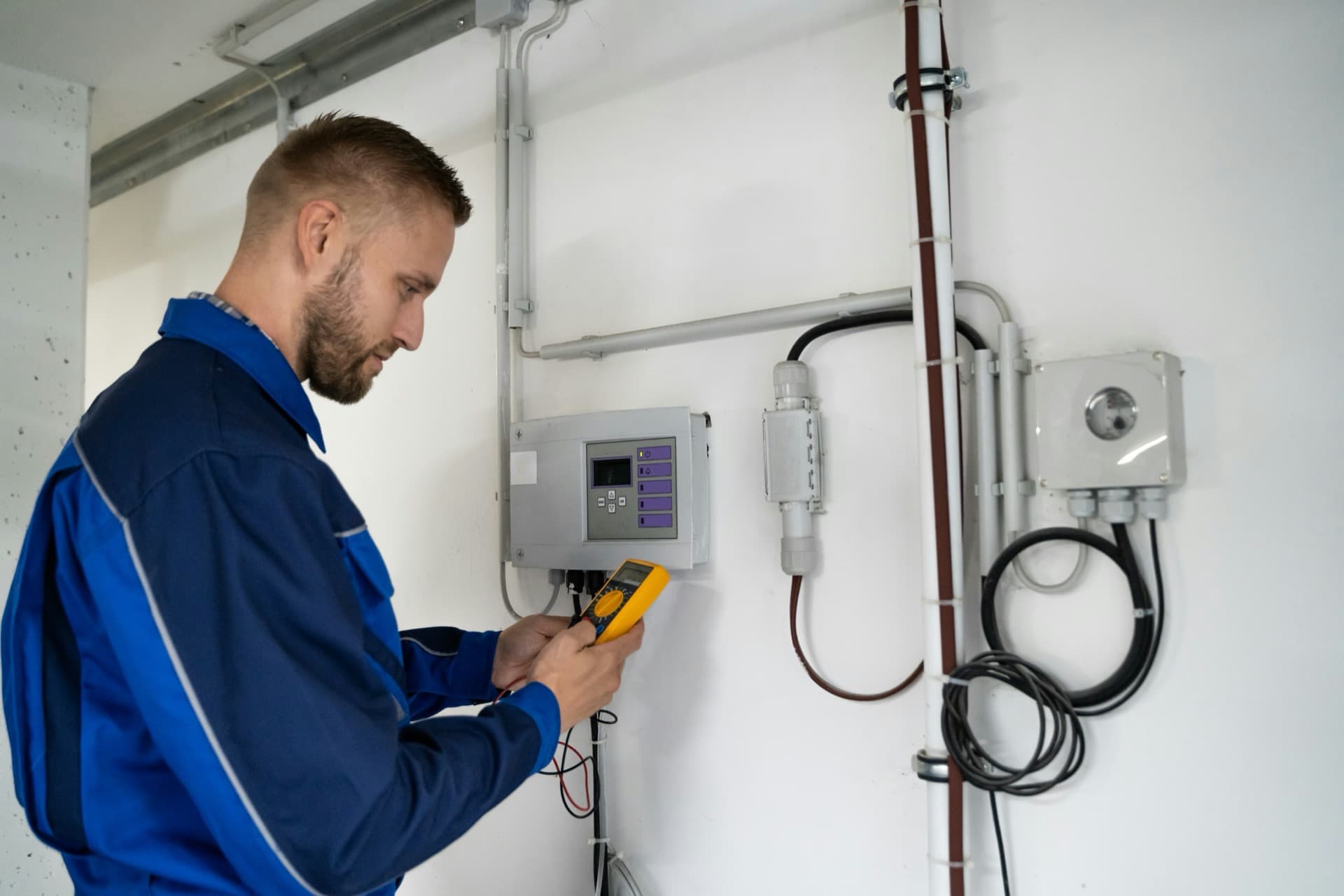 Technician using a meter during equipment diagnostics.